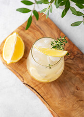 Mojito cocktail with fresh lemon, mint and ice. Refreshing citrus lemonade drink on a wooden board...