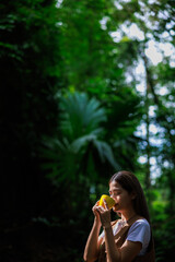 Fototapeta premium women enjoying her coffee during weekend during hiking activity in the rainy season, green big tree forest nature backgrounds.