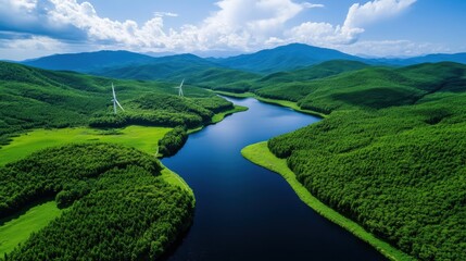 Fototapeta premium Aerial view of a serene river flowing through lush green mountains under a blue sky, showcasing nature's beauty and tranquility.