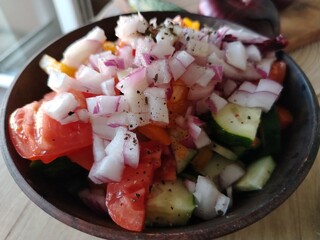 chopped onions tomatoes zucchini cucumbers in a ceramic bowl