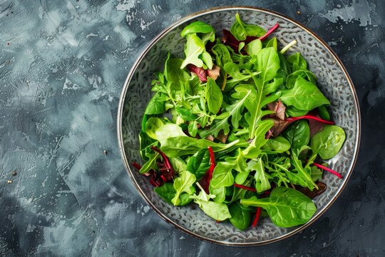 Top view of salad bowl with baby spinach arugula basil chard and lambs lettuce mix Healthy food