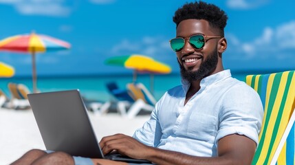 A man is sitting on a beach chair with a laptop in front of him. He is smiling and he is enjoying his time