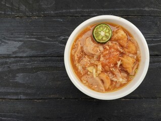 Indonesian street food spicy seblak in bowl on the wooden table