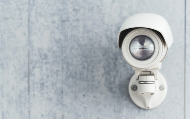 Close-up of a modern security camera mounted on a wall, emphasizing safety and surveillance technology for home and business use.