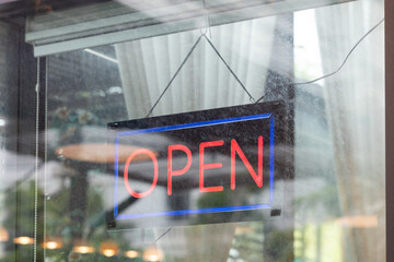 Fototapeta premium A neon sign hanging from a window that says 