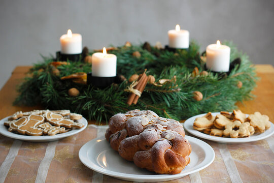 Traditional Czech and Slovak Christmas sweet plaited bread called vanocka (in Slovak vianocka). Christmas pastry on a festively set table, an advent wreath with four burning candles in the background.