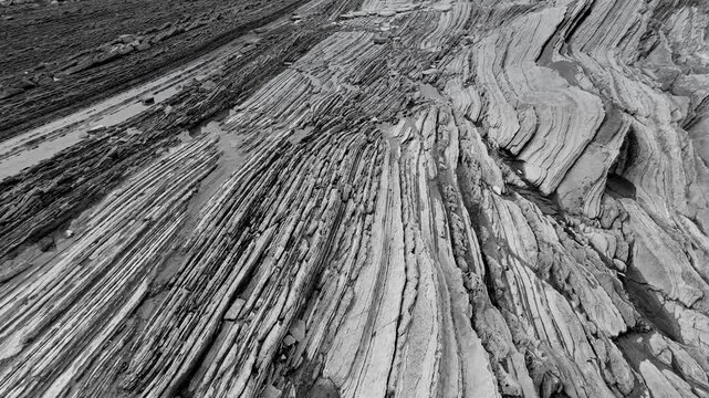 Rock textures at low tide at the Sakoneta Flysch and Punta Mendata on the Cantabrian Coast in Deva. Aerial view from a drone. Cantabrian Sea. Gipuzkoa Province. Basque Country. Spain. Europe