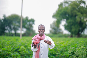 Naklejka premium Indian farmer, equipped with a miniature tractor toy