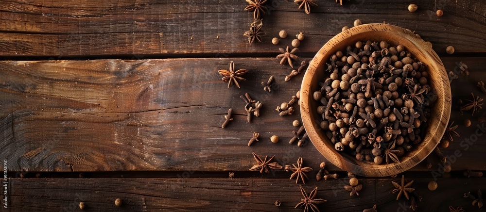 Leinwandbilder top view of a wooden table with a bowl of aromatic dry cloves offering a copy space image for text