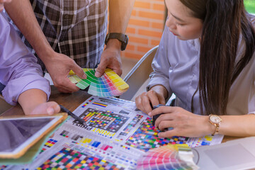 Worker checking print quality of media graphics proof print and color tone in printing industry....