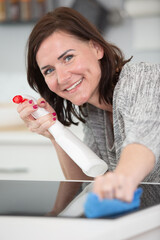 young woman cleans an induction hob