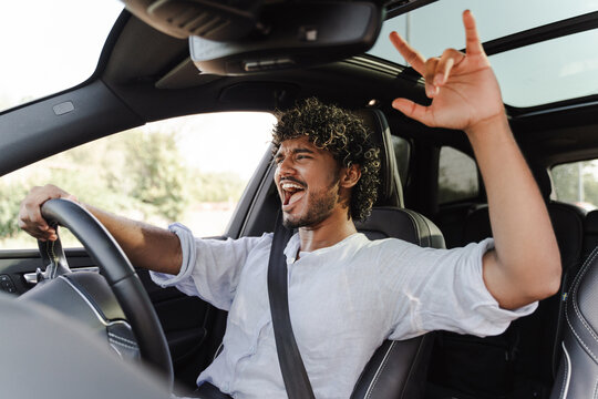 Excited, Indian man singing and enjoying while driving car
