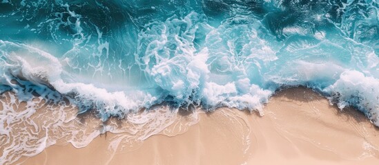Tropical waves create a scenic ocean background with a sandy shore white foam and a serene natural view suitable for a copy space image