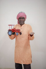 Indian farmer, equipped with a miniature tractor toy