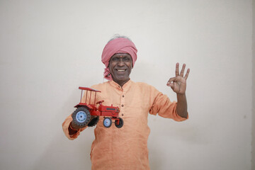 Indian farmer, equipped with a miniature tractor toy