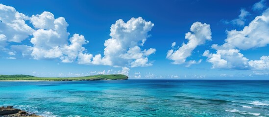 Scenic coastal view with clear blue skies and fluffy clouds on a sunny day featuring a wide copy space image