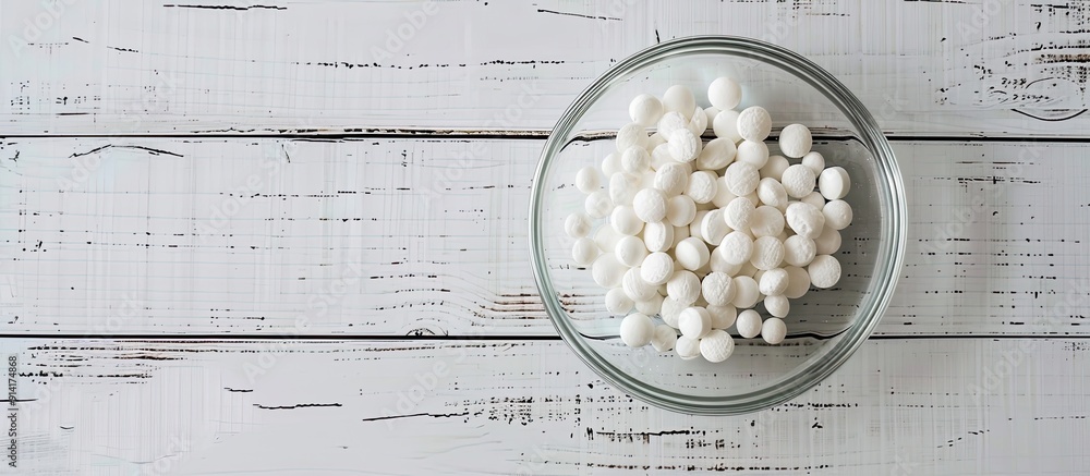Aufkleber glass dish with sugar coated pills placed on a white wooden surface creating a visually appealing co
