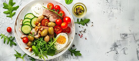 Keto dinner plate with boiled pork avocado guacamole tomatoes cucumbers mozzarella olives and arugula on a white table Detox and health concept Shot from the top showing a copy space image
