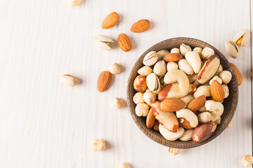 Healthy mix nuts on wooden background. Almonds, hazelnuts, cashews, peanuts, pistachios, Brazil nuts