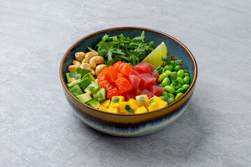 Poke bowl with salmon and tuna on a gray background