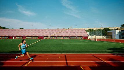 Motivated young athlete practicing for pole vaulting championship, competitive and focused man in...