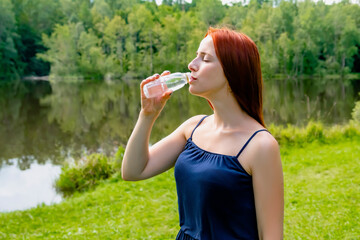 Beautiful fitness athlete slender young woman drinking water after workout exercising near lake,river,mind detox relaxing.inspiration nature beauty harmony landscape outdoors