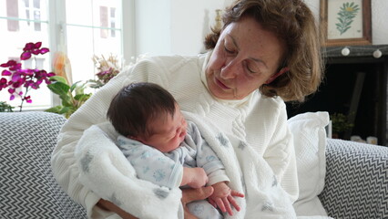 Grandmother lovingly holding newborn baby, tender family bonding moment, peaceful home interior, intergenerational connection, grandmother's care and love