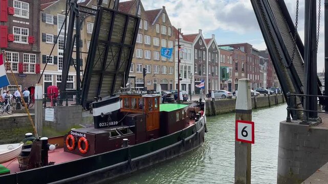 Raising the bridge in Dordrecht to allow ships to pass through the canal. A beautiful drawbridge in the Netherlands. Beautiful canal, river in the city. The ship sails through the canal.
