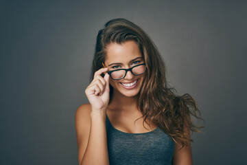 Woman, portrait and happy with glasses in studio on grey background for prescription, eyewear and eyesight. Female person, smile and satisfied or confident with frame for spectacles, lens and vision