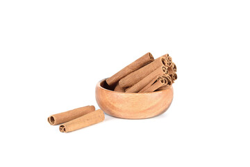 Cassia spice sticks in wooden bowl and on white background.
