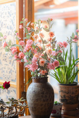 Fototapeta premium Bouquet of dry roses in vintage vase near the window