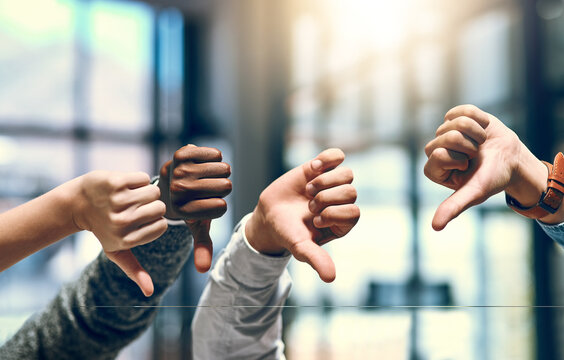 Business people, thumbs down and no with bad review for negative feedback or disapproval at office. Closeup of group, employees or team with hands for emoji, fail or mistake together at workplace