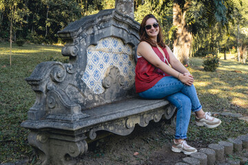 Brazilian woman posing on a couch, in the Jardim Botanical Garden in São Paulo, Brazil.