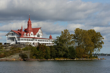a historic seaside building with distinctive red roofs, nestled on a small island by the waterfront