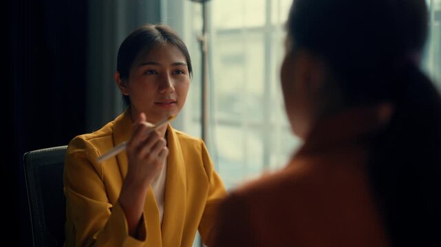 Two businesswomen in a modern office space, having a serious conversation, exchanging ideas with expressive gestures. Perfect for business, teamwork, and communication concepts