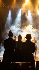 Fototapeta premium Performers stand in silhouette, preparing to go on stage as smoke and lights create an atmospheric backdrop