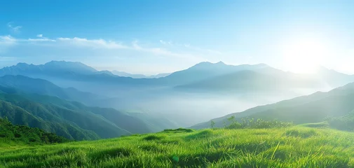Fototapeten Breathtaking mountain landscape with green grass, serene atmosphere, and soft sunlight illuminating the horizon. © Arrseman