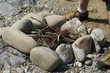 a man breaks branches for a fire, making a fire for cooking