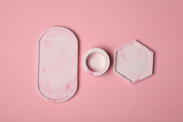 Set of Decorative pink plaster trays of different shapes on a pink background. Stands for candles...