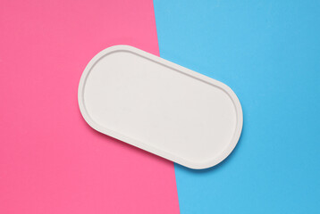 Plaster oval tray on a pink blue background. Top view. Creative layout