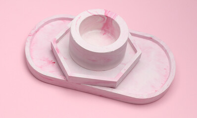 Set of Decorative pink plaster trays of different shapes on pink pastel background. Stands for candles organizers for cosmetics or jewelry.