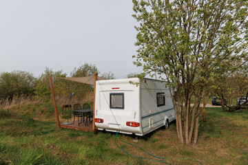 Caravan or camper trailer with Wooden Deck at Countryside Glamping Site. Outdoor Camping