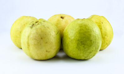 five half ripe red guavas on a white isolated background