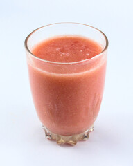 A glass of fresh looking red guava juice on a white isolated background