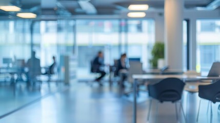A blurry office scene with people sitting at desks and a few chairs