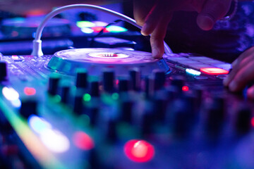 Obraz premium Professional DJ Performing Live Mixes at an Exciting Nightclub Party with Colorful Lighting Effects