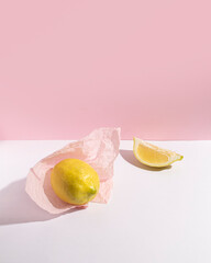 Ripe lemon wrapped in pastel pink paper.