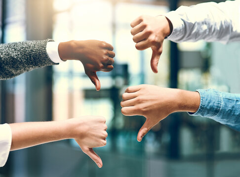 Office, disagreement and business people with thumbs down for vote, no and choice for creative agency. Teamwork, employees or managers with hands gesture for opinion, feedback and rejection by flare