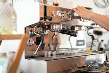 Fresh coffee dropping from the coffee making machine down into the cup. Drink and object, close-up and selective focus.