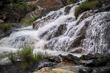 powerful wide waterfall with white foaming water